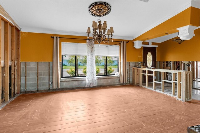 unfurnished dining area featuring ornamental molding, a chandelier, and wood finished floors