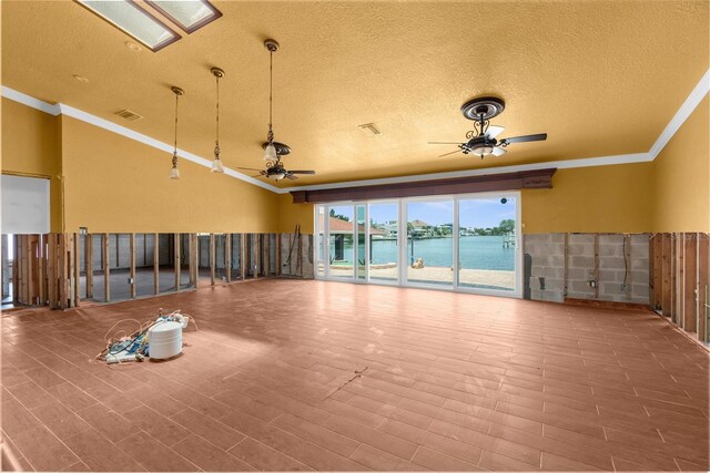 unfurnished room featuring crown molding, ceiling fan, a water view, a textured ceiling, and wood finished floors
