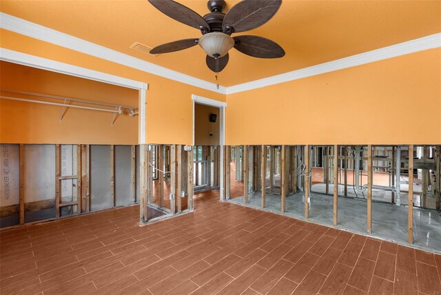 empty room featuring ornamental molding, ceiling fan, and wood finished floors