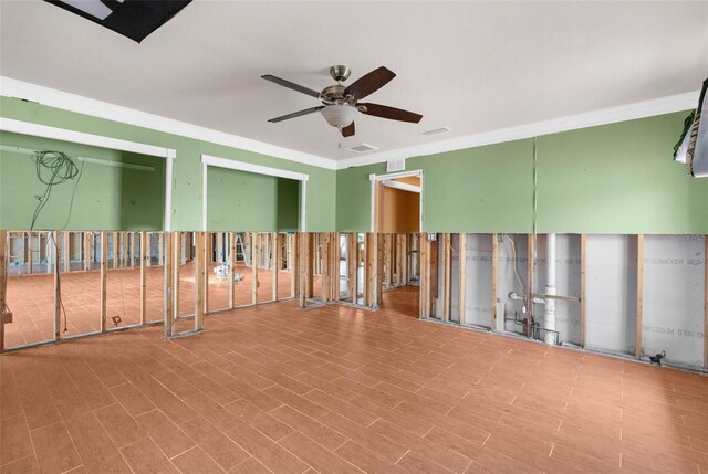 empty room featuring ceiling fan and ornamental molding