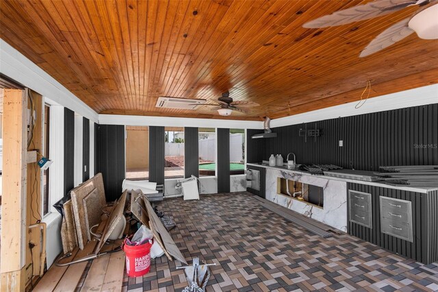 view of patio featuring exterior kitchen, ceiling fan, and fence