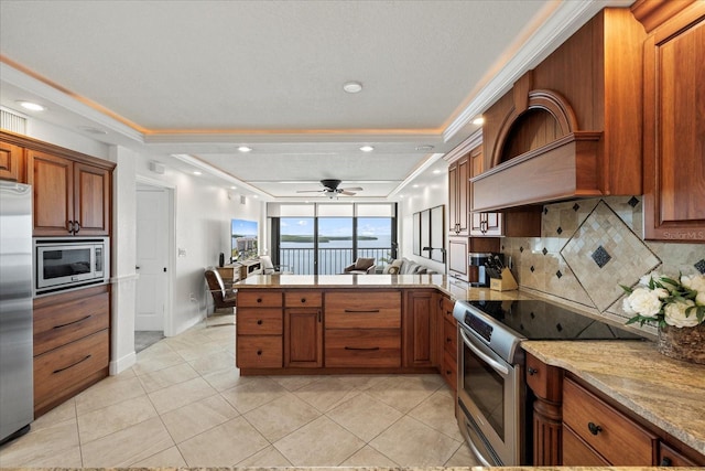 4550 Bay Blvd Unit 1231, Port Richey, FL 34668 - kitchen with stainless steel appliances, a peninsula, tasteful backsplash, brown cabinets, and light tile patterned floors