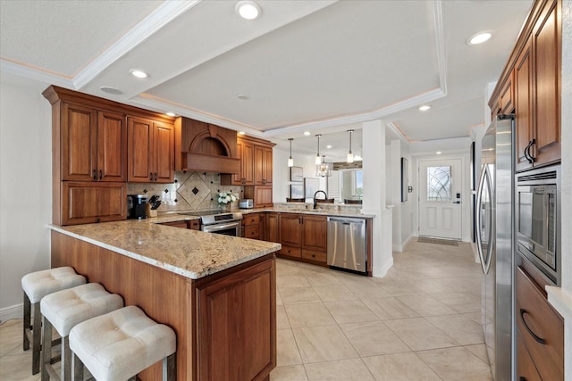 4550 Bay Blvd Unit 1231, Port Richey, FL 34668 - kitchen with stainless steel appliances, a peninsula, crown molding, premium range hood, and brown cabinets