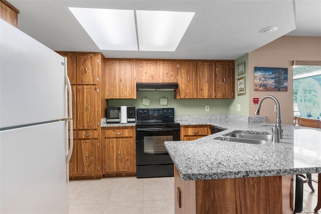 kitchen with a peninsula, a sink, freestanding refrigerator, black range with electric stovetop, and under cabinet range hood