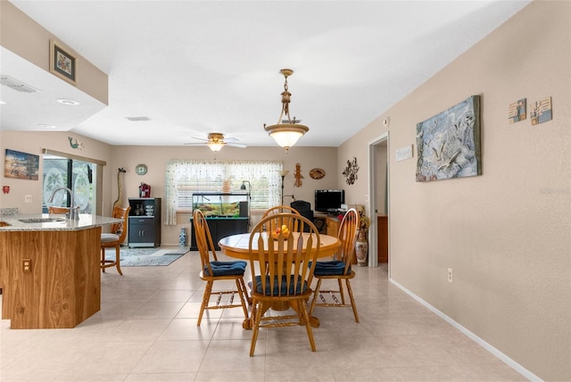 dining room with light tile patterned floors, visible vents, baseboards, and a ceiling fan