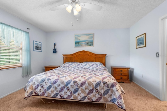 bedroom with light colored carpet, a textured ceiling, baseboards, and ceiling fan