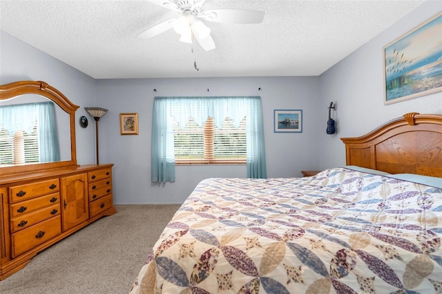 carpeted bedroom featuring ceiling fan and a textured ceiling