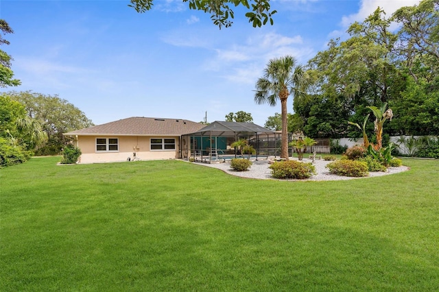 back of property with stucco siding, a fenced in pool, and a lawn