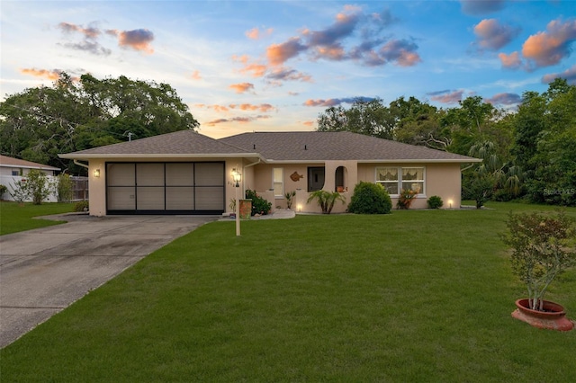 ranch-style home with concrete driveway, stucco siding, a garage, and a lawn