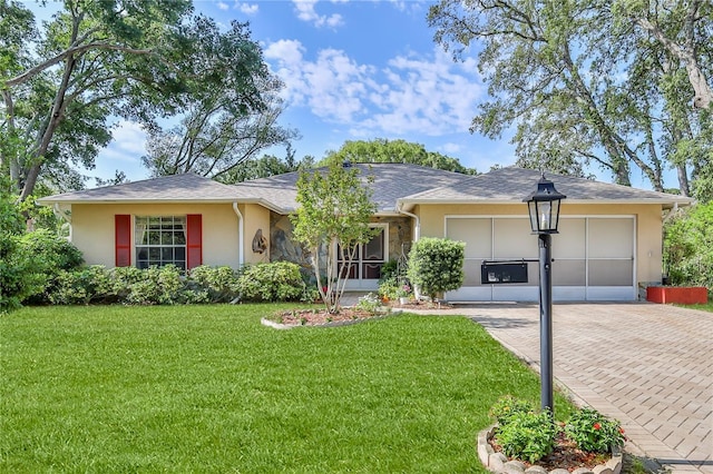 single story home with stucco siding, a front lawn, and decorative driveway