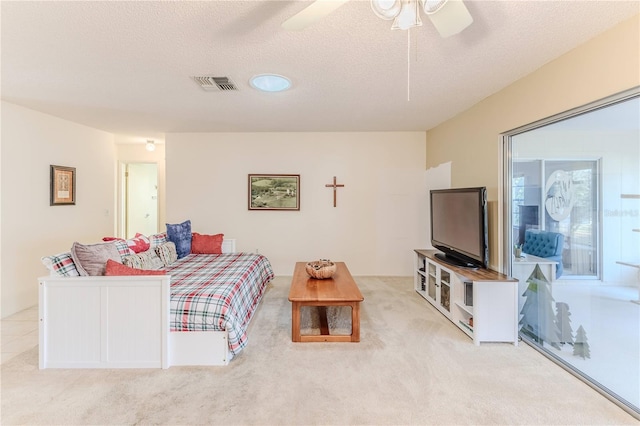 bedroom with carpet, a textured ceiling, visible vents, and a ceiling fan
