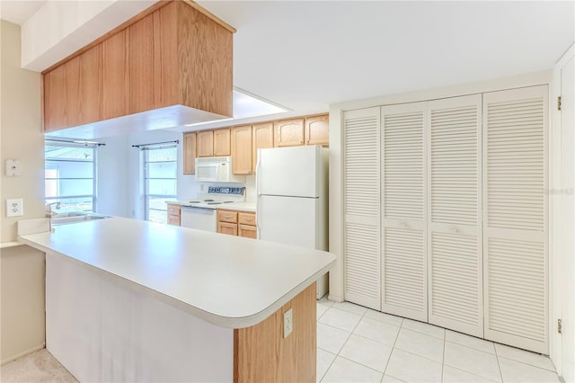 kitchen with light brown cabinetry, white appliances, a sink, a peninsula, and light countertops