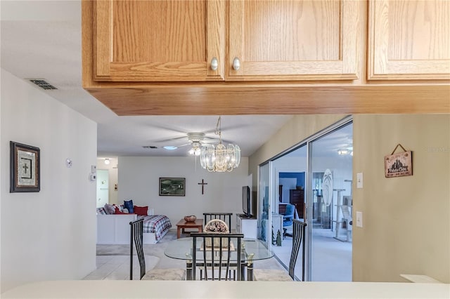 dining area featuring ceiling fan with notable chandelier and visible vents