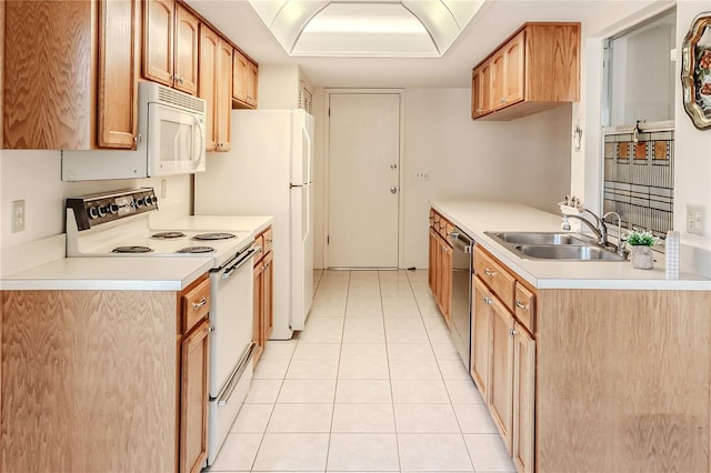 kitchen featuring light countertops, light tile patterned floors, a sink, and white appliances