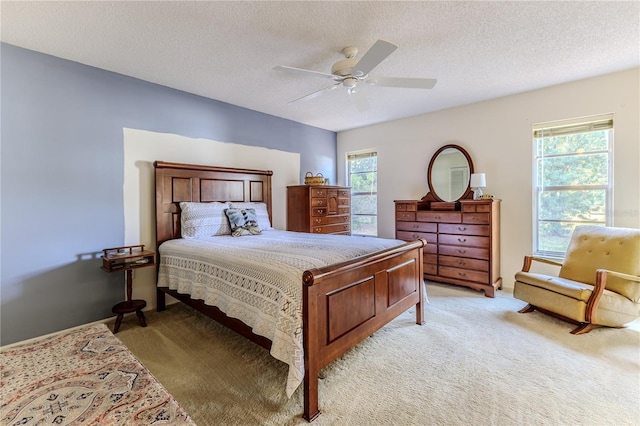 bedroom with light colored carpet, a textured ceiling, and ceiling fan