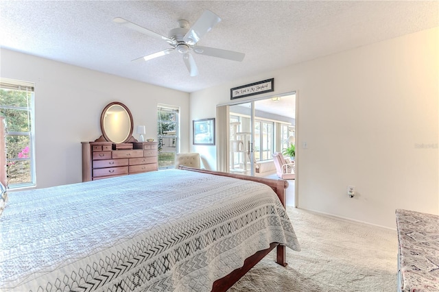 carpeted bedroom with ceiling fan, a textured ceiling, access to exterior, and multiple windows