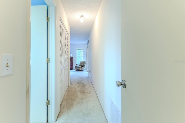 hall with light carpet and visible vents