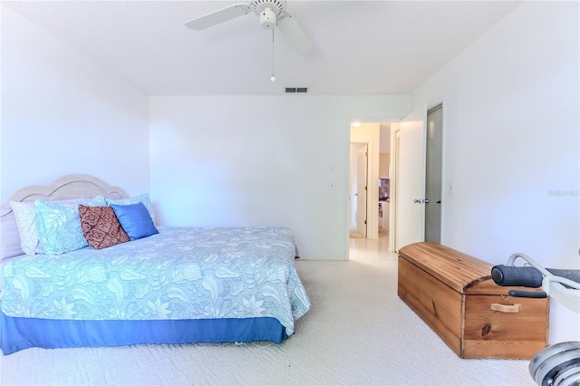 carpeted bedroom featuring a ceiling fan and visible vents