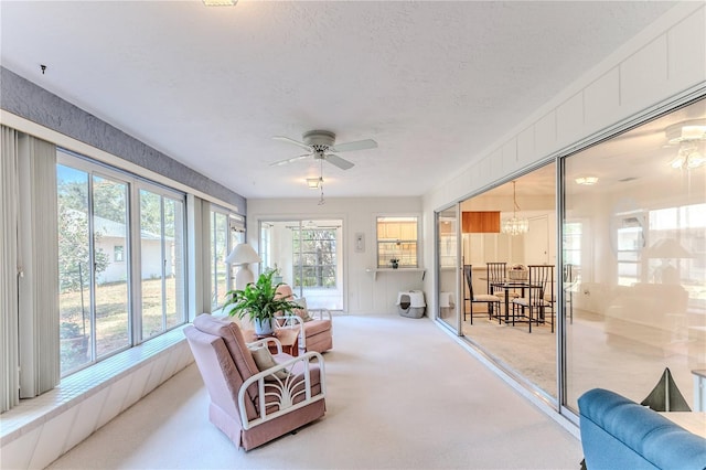 sunroom featuring a textured ceiling, a notable chandelier, and carpet floors