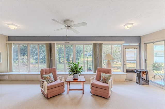 sunroom with carpet floors, a healthy amount of sunlight, and a textured ceiling