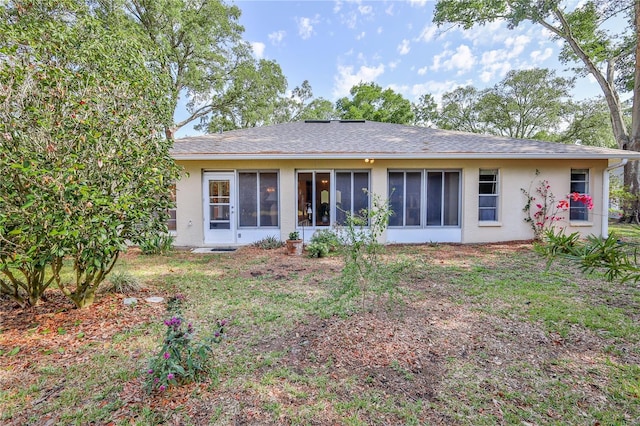 rear view of property with a sunroom and stucco siding