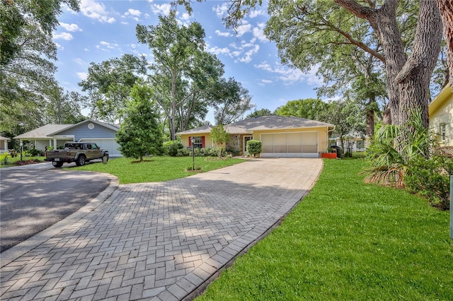 ranch-style house featuring a front lawn, a garage, and decorative driveway