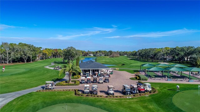 drone / aerial view with a water view and view of golf course