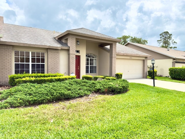 view of front of home featuring brick siding, a garage, a front yard, concrete driveway, and roof with shingles