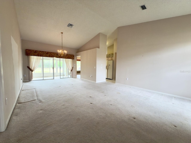 empty room with light colored carpet, a chandelier, baseboards, lofted ceiling, and a textured ceiling