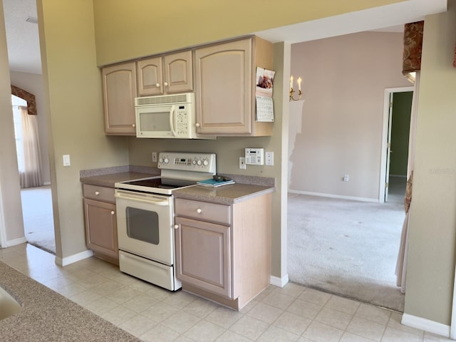 kitchen with white appliances, light carpet, baseboards, and light tile patterned floors