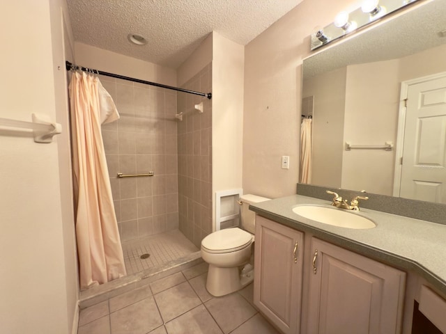 bathroom featuring toilet, a tile shower, vanity, tile patterned flooring, and a textured ceiling