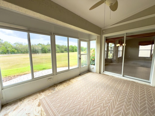 unfurnished sunroom featuring a ceiling fan and vaulted ceiling