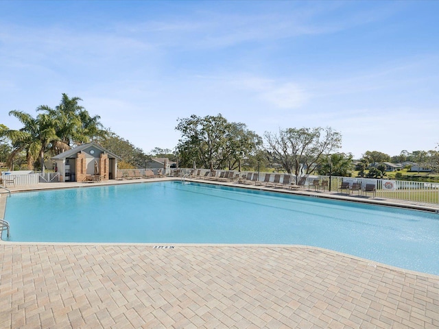 community pool featuring fence and a patio