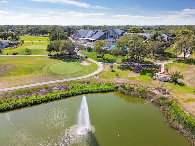 drone / aerial view of a large body of water, a tree filled landscape, and a golf course