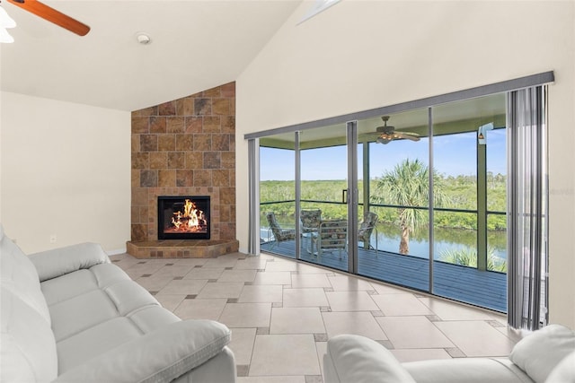 6321 Garland Ct, New Port Richey, FL 34652 - tiled living room featuring ceiling fan, a tiled fireplace, a water view, and high vaulted ceiling