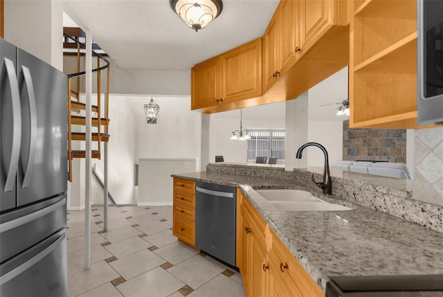6321 Garland Ct, New Port Richey, FL 34652 - kitchen featuring appliances with stainless steel finishes, a sink, a chandelier, ceiling fan, and light stone countertops