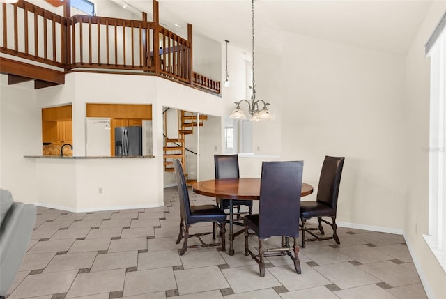6321 Garland Ct, New Port Richey, FL 34652 - dining room featuring stairs, high vaulted ceiling, a chandelier, baseboards, and tile patterned floors
