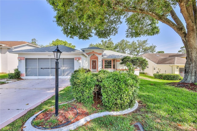 ranch-style house with a garage, concrete driveway, stucco siding, and a front yard