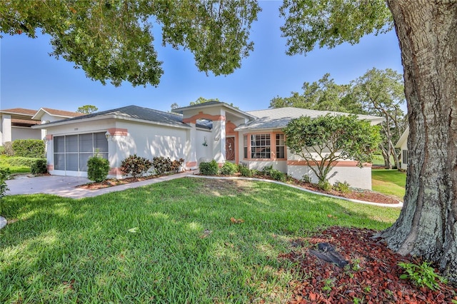 single story home with a front lawn, a garage, driveway, and stucco siding