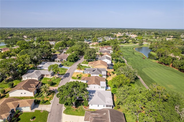 aerial view of residential area featuring a nearby body of water and a local golf course