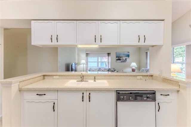 kitchen with dishwasher, white cabinets, and a sink