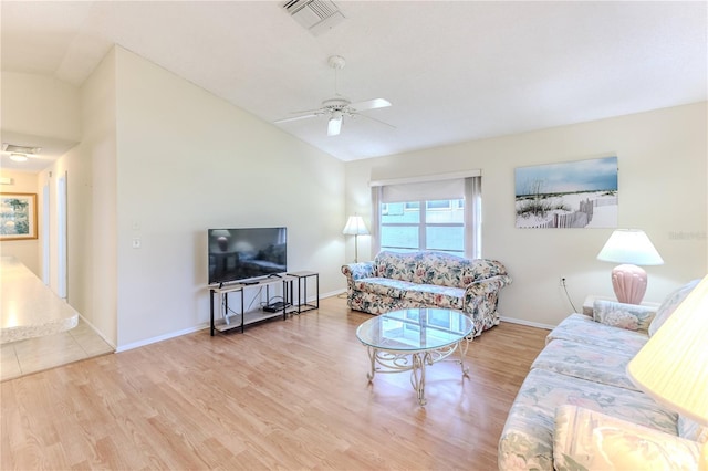living room featuring vaulted ceiling, wood finished floors, ceiling fan, and baseboards