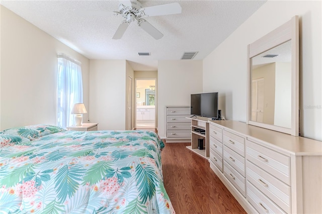 bedroom featuring dark wood-type flooring, a textured ceiling, a ceiling fan, and ensuite bathroom