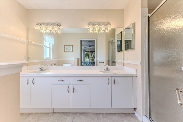 full bath featuring a shower stall, double vanity, and tile patterned floors