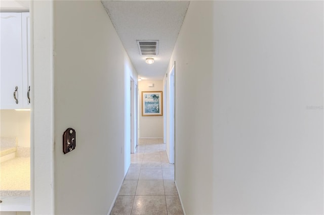 hall with light tile patterned flooring and baseboards