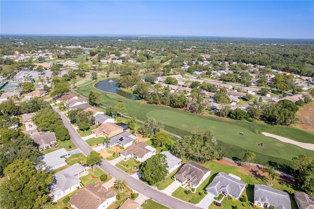 aerial view of property's location with a local golf course, a large body of water, and nearby suburban area