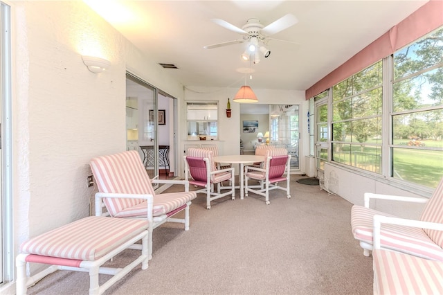 sunroom featuring a ceiling fan and outdoor dining space