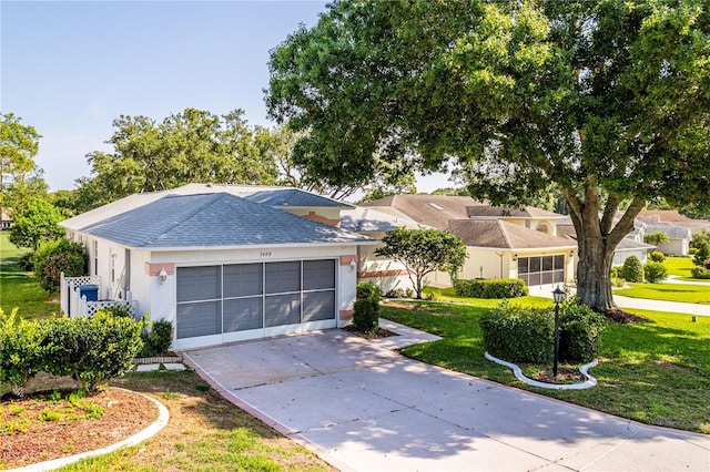 ranch-style home with a front lawn, roof with shingles, concrete driveway, and a garage