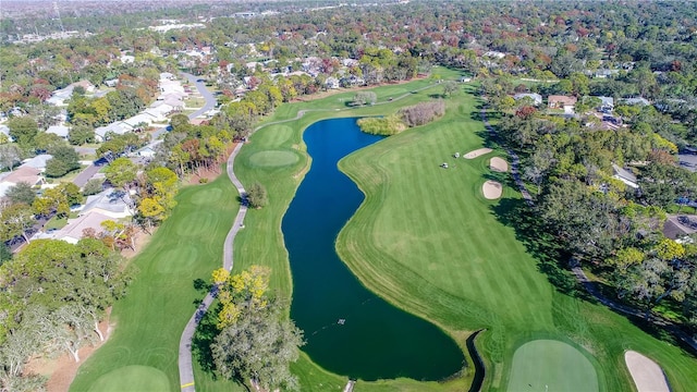 view of property location with a large body of water, nearby suburban area, and a tree filled landscape