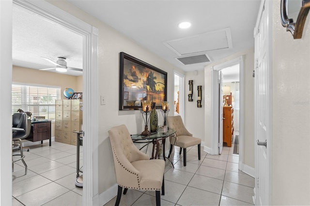 hall with attic access, light tile patterned floors, a desk, and baseboards